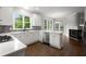 Bright kitchen features white cabinetry, quartz countertops, stainless appliances, and tiled backsplash at 710 Glen Royal Dr, Roswell, GA 30076