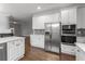 Modern kitchen with stainless steel appliances, white cabinets, and stylish backsplash at 710 Glen Royal Dr, Roswell, GA 30076