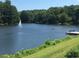 Beautiful lake view featuring a sailboat on the water and a dock with benches, creating a serene and inviting atmosphere at 710 Glen Royal Dr, Roswell, GA 30076