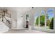 Bright living room features large arched windows, staircase with wood railing, and neutral paint at 710 Glen Royal Dr, Roswell, GA 30076