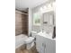 Bathroom with ceramic tile shower and flooring, white vanity, and natural light at 7629 Park Ln, Jonesboro, GA 30236