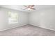 Bright bedroom features plush gray carpeting, a ceiling fan, and a window with natural light at 7629 Park Ln, Jonesboro, GA 30236