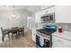 Charming kitchen with stainless steel appliances, marble counters, and dining table with modern light fixture at 7629 Park Ln, Jonesboro, GA 30236