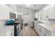 Well-lit kitchen with white cabinets, modern stainless steel appliances, and wood-look flooring at 7629 Park Ln, Jonesboro, GA 30236
