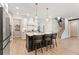Spacious kitchen with island seating and stainless appliances adjacent to stairs at 3672 Silvery Way, Powder Springs, GA 30127