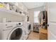 Efficient laundry room with modern washer and dryer, ample shelving, and storage baskets for organization at 3672 Silvery Way, Powder Springs, GA 30127