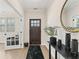 Inviting foyer with light wood floors, black accents, a decorative mirror and french doors at , Powder Springs, GA 30127