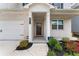 Charming front porch area with a wood door, white brick, manicured landscaping, and a paved walkway at , Powder Springs, GA 30127