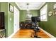 Bedroom showing exercise bike, stylish storage cabinet, hardwood floors, green walls, and crown molding at 1125 Briarcliff Ne Pl # 14, Atlanta, GA 30306