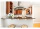 Modern kitchen featuring wooden cabinets, granite countertops, stainless steel vent hood, and two bar stools at 1125 Briarcliff Ne Pl # 14, Atlanta, GA 30306