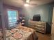 Comfortable bedroom featuring a ceiling fan, dresser, and a large window for natural light at 1935 Flat Shoals Se Rd, Conyers, GA 30013