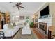 Bright living room featuring a cozy fireplace, plush sectional sofa, and a ceiling fan at 2229 Polder Way, Austell, GA 30168