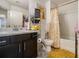 Well-lit bathroom features a dark vanity, neutral wall paint, and a tub with shower and curtain at 2404 Fitts Dr, Conyers, GA 30094
