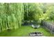 Landscaped backyard featuring a willow tree, Adirondack chairs, fire pit, and fenced perimeter providing a relaxing outdoor retreat at 925 Hill Se St, Atlanta, GA 30315
