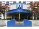 Building entrance with blue facade, manicured greenery, and prominent signage at 1130 Piedmont Ne Ave # 410, Atlanta, GA 30309