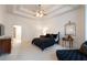 Elegant bedroom featuring a tray ceiling, ceiling fan, and decoratively appointed furnishings at 185 Windsor Cv, Sandy Springs, GA 30328