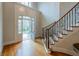 Bright foyer with hardwood floors, a grand staircase with iron railings, and an arched doorway at 185 Windsor Cv, Sandy Springs, GA 30328