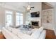 Bright living room features vaulted ceilings, fireplace, built-in shelving, and a comfortable white sofa at 185 Windsor Cv, Sandy Springs, GA 30328
