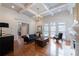 Bright living room with hardwood floors, coffered ceiling, fireplace, large windows, and comfortable seating at 185 Windsor Cv, Sandy Springs, GA 30328