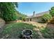 Backyard with lawn, wooden fence, patio, mature trees and a brick-lined fire pit at 2889 Estuary Dr, Acworth, GA 30101