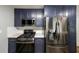 Modern kitchen with navy cabinets, stainless steel appliances, and granite countertops at 2889 Estuary Dr, Acworth, GA 30101