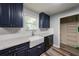 Charming kitchen features navy blue cabinets, white subway tile, a farmhouse sink, and stainless steel appliances at 2889 Estuary Dr, Acworth, GA 30101