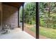 Covered back porch with brick accents overlooking a landscaped backyard at 320 Wisteria Cir, Roswell, GA 30076
