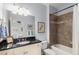 Bathroom with black granite counters, tiled shower-tub, and white cabinets at 320 Wisteria Cir, Roswell, GA 30076