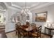 Formal dining room features a chandelier, wainscoting, and a large wood dining table at 320 Wisteria Cir, Roswell, GA 30076