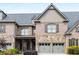 Charming townhome with stone and brick exterior, two-car garage and manicured landscaping at 320 Wisteria Cir, Roswell, GA 30076