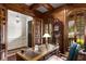 Office with wood paneling, built-in shelves, an antique desk, and a comfortable chair at 320 Wisteria Cir, Roswell, GA 30076