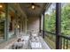 Covered porch with brick floor, wood columns, and iron railing provides a relaxing outdoor living space at 320 Wisteria Cir, Roswell, GA 30076