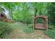 Backyard with a stone path leading to a wood swing among the trees at 4066 Brymond Ct, Tucker, GA 30084