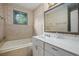 Cozy bathroom featuring a tiled tub, round window, and decorative wallpaper at 4066 Brymond Ct, Tucker, GA 30084