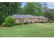 Traditional brick home featuring manicured lawn, mature landscaping, and classic architectural details at 4066 Brymond Ct, Tucker, GA 30084