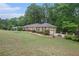 Ranch home with brick facade, attached two-car garage, mature trees, and manicured front lawn at 4066 Brymond Ct, Tucker, GA 30084