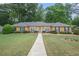 Charming brick home with mature landscaping, lush lawn, and inviting walkway to the front door at 4066 Brymond Ct, Tucker, GA 30084