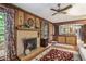 Cozy living room featuring a brick fireplace, wood-paneled walls, and a ceiling fan at 4066 Brymond Ct, Tucker, GA 30084