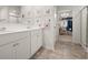 Bright bathroom featuring double sinks, white cabinetry, and a walk-in closet with a chandelier at 108 Berwick Crossing, Dallas, GA 30157