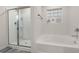 Bathroom showcasing a soaking tub, glass block window, and a separate glass-enclosed shower at 108 Berwick Crossing, Dallas, GA 30157