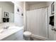 Clean, well-lit bathroom features a vanity with a mirror, decorative wall art, and a shower with a curtain at 108 Berwick Crossing, Dallas, GA 30157