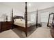 Bedroom featuring a dark wood four poster bed, neutral walls, and dual windows for natural light at 108 Berwick Crossing, Dallas, GA 30157