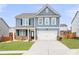 Charming two-story home with blue siding, a well-manicured lawn, and a two-car garage at 108 Berwick Crossing, Dallas, GA 30157