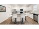 Modern kitchen with stainless steel appliances, granite countertops, and a stylish island with bar stool seating at 108 Berwick Crossing, Dallas, GA 30157