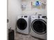 Laundry area with modern front-load washer and dryer with shelving above on stone flooring at 108 Berwick Crossing, Dallas, GA 30157