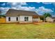 View of the home's rear exterior, showcasing the back porch and brick patio on a large lawn at 25 Oakbrook Ln, Covington, GA 30016