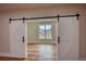 Close up of white sliding barn doors leading to another room with a window at 25 Oakbrook Ln, Covington, GA 30016