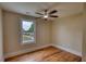 Bright bedroom featuring hardwood floors, a ceiling fan, and a window offering an outdoor view at 25 Oakbrook Ln, Covington, GA 30016