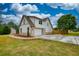 Side view showcasing the home's exterior, with a driveway leading to the garage and a well-kept lawn at 25 Oakbrook Ln, Covington, GA 30016