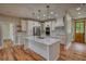 Bright kitchen boasts white cabinets, a center island with a sink, stainless steel appliances and pendant lighting at 25 Oakbrook Ln, Covington, GA 30016